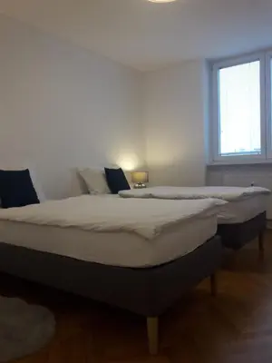 a bedroom with two beds in a room with a window at Apartment Emona Ljubljana in Ljubljana