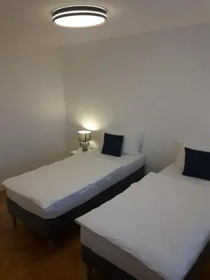 two twin beds in a room with a light at Apartment Emona Ljubljana in Ljubljana