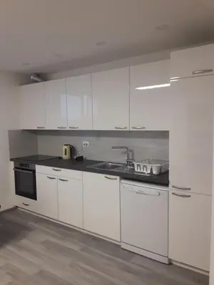a kitchen with white cabinets and a sink at Apartment Emona Ljubljana in Ljubljana