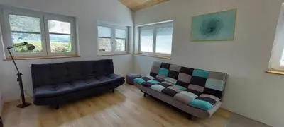 a living room with a couch and a chair at Počitniška hiška v grapi in Tolmin