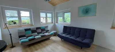 a living room with a couch and a chair at Počitniška hiška v grapi in Tolmin