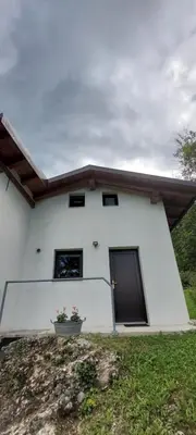 a white house with a plant in front of it at Počitniška hiška v grapi in Tolmin