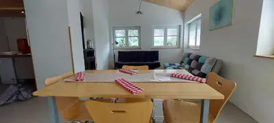 a table and chairs in a room with a couch at Počitniška hiška v grapi in Tolmin