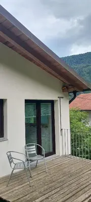 a pair of chairs sitting on a wooden deck at Počitniška hiška v grapi in Tolmin
