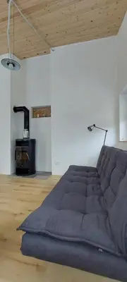 a large couch in a living room with a table at Počitniška hiška v grapi in Tolmin