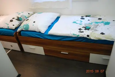 a bed with a wooden frame and pillows on it at Apartment Center 25 in Ljubljana