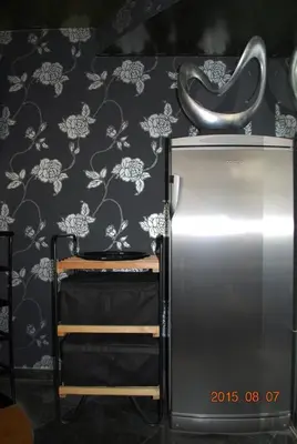 a refrigerator next to a wall with floral wallpaper at Apartment Center 25 in Ljubljana