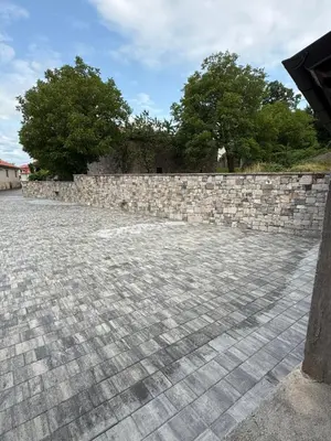 a stone retaining wall next to a stone wall at House Mohar in Lokev