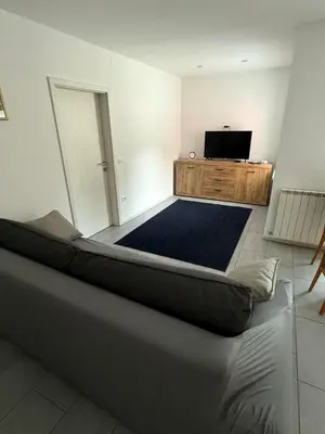 a living room with a bed and a flat screen tv at House Mohar in Lokev