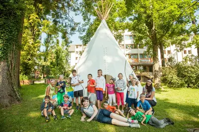 a group of children posing for a picture in front of a tent at Youth Hostel Proteus Postojna in Postojna