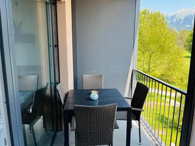 a table and chairs on a balcony with a view at Vitan Apartment in Bled