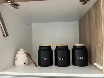 three black containers sitting on a shelf at Vitan Apartment in Bled
