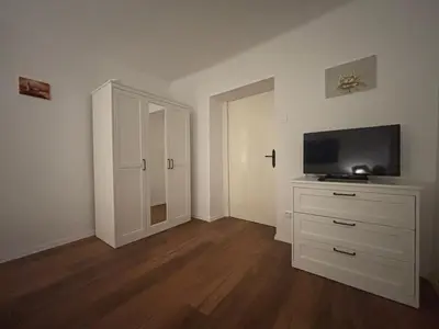 a room with a white dresser with a flat screen tv at The Green City Apartment in Ljubljana