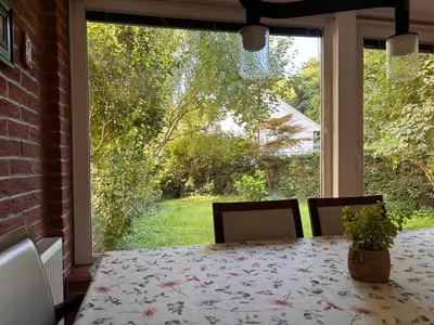 a dining room with a table and a large window at The Green City Apartment in Ljubljana