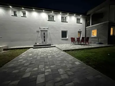 a house with chairs and a patio at night at Apartma Viković