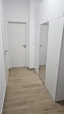an empty room with white cabinets and a mirror at Memento Ljubljana Apartments with Private Bathrooms & Shared Kitchen in Ljubljana