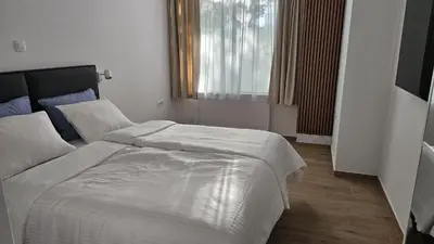 a bedroom with a large white bed and a window at Memento Ljubljana Apartments with Private Bathrooms & Shared Kitchen in Ljubljana