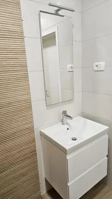 a white bathroom with a sink and a mirror at Memento Ljubljana Apartments with Private Bathrooms & Shared Kitchen in Ljubljana