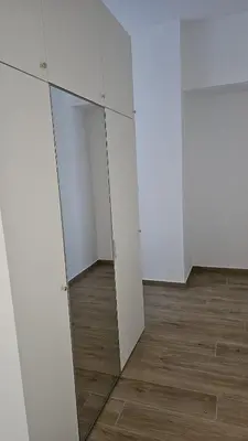 a room with white cabinets and a mirror at Memento Ljubljana Apartments with Private Bathrooms & Shared Kitchen in Ljubljana