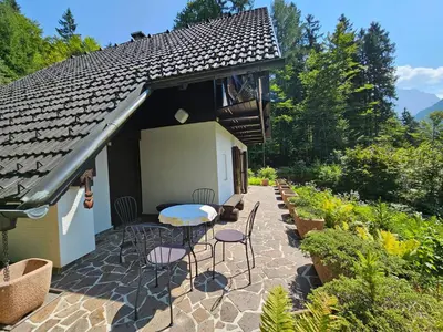 a patio with a table and chairs and a house at Chalet 61 Lake Jasna in Kranjska Gora