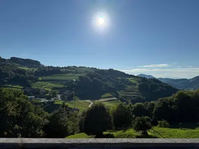 a view of a valley with the sun in the sky at ART Nature Retreat in Gorica pri Slivnici