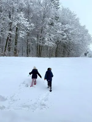 two people walking in the snow at ART Nature Retreat in Gorica pri Slivnici