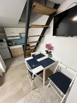 a living room with a table and a staircase at CC Vič in Ljubljana