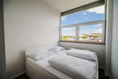 a bed in a room with two pillows and a window at Comfort Rooms Obrežje by Highway, Free Covered Parking in Jesenice na Dolenjskem