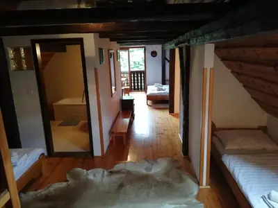 a living room with two beds and a mirror at Guest House Turistična kmetija Plaznik in Ljubno