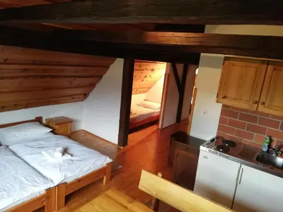 a small room with a bed and a kitchen at Guest House Turistična kmetija Plaznik in Ljubno