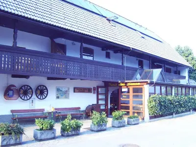 a building with potted plants in front of it at Guest House Turistična kmetija Plaznik in Ljubno