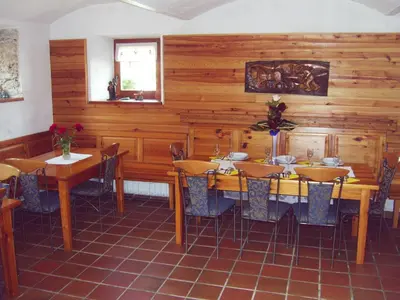 a dining room with wooden walls and tables and chairs at Guest House Turistična kmetija Plaznik in Ljubno
