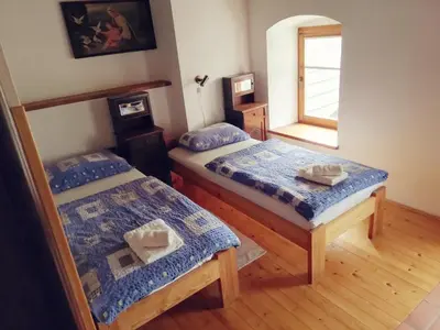 a bedroom with two beds and a window at Guest House Turistična kmetija Plaznik in Ljubno