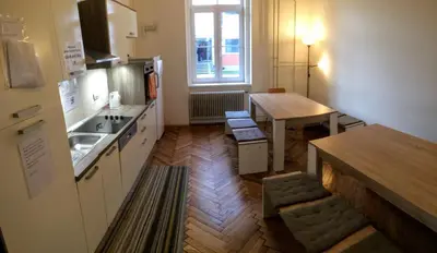 a small kitchen with a table and a table and a dining room at C - Punkt Hostel in Ljubljana