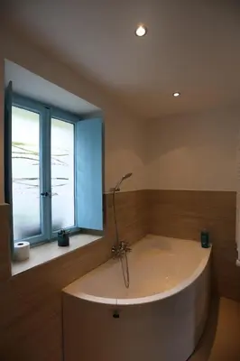 a bath tub in a bathroom with a window at Hiša Nad Reko Baca in Most na Soči