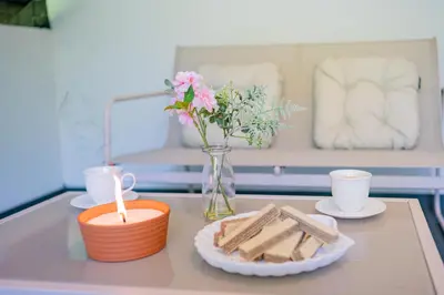 a table with a candle and a vase of flowers and cookies at Apartments Lian in Bled