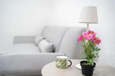 a coffee table with a vase of flowers and a lamp at Apartments Lian in Bled
