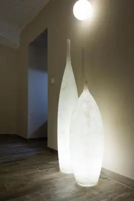 two white vases sitting on the floor in a room at Cacao Rooms in Ljubljana