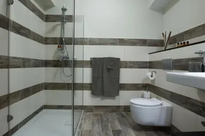 a bathroom with a shower and a toilet and a sink at Cacao Rooms in Ljubljana