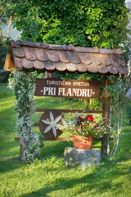a sign in the grass with flowers on it at Farm Pri Flandru in Cerkno