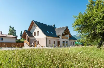 a large white house with a green roof at Gostilna in picerija Harlekin in Ribnica