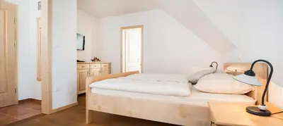 a bedroom with a bed and a desk with a lamp at Gostilna in picerija Harlekin in Ribnica