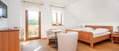 a bedroom with a bed and a desk and a table at Gostilna in picerija Harlekin in Ribnica