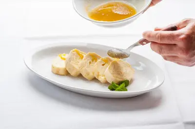 a person eating food on a plate with a spoon at Gostilna in picerija Harlekin in Ribnica