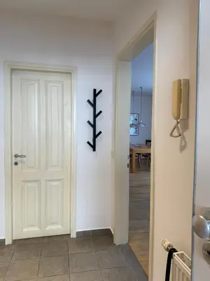 a hallway with a white door with a cross on the wall at City Nest Ljubljana - Terrace & Free Parking in Ljubljana