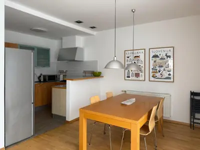 a kitchen and dining room with a wooden table at City Nest Ljubljana - Terrace & Free Parking in Ljubljana