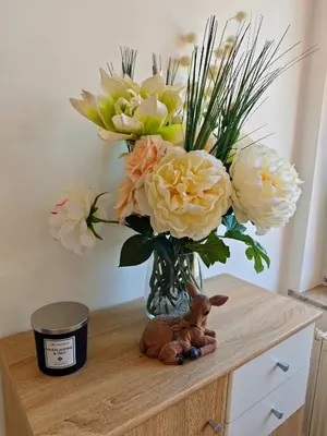a vase with a bouquet of flowers on a table at Soba Amaris bianco in Benedikt v Slovenskih Goricah