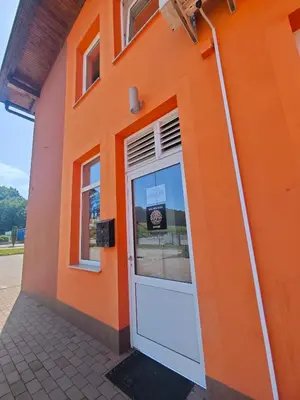 an orange building with a door in front of it at Soba Amaris bianco in Benedikt v Slovenskih Goricah