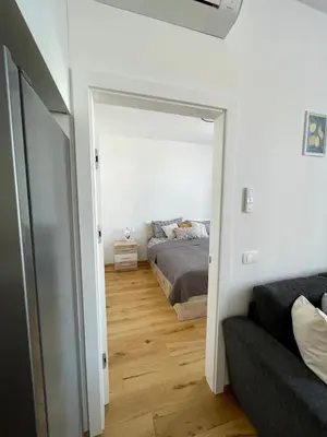 a bedroom with a bed and a couch and a mirror at Mirno in elegantno stanovanje - Parkirišče, Netflix, wifi in Maribor