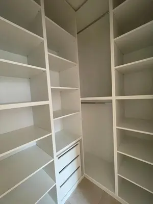 a white walk in closet with white shelves at Mirno in elegantno stanovanje - Parkirišče, Netflix, wifi in Maribor